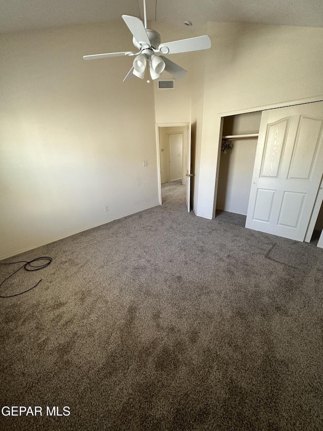 unfurnished bedroom featuring high vaulted ceiling, ceiling fan, carpet flooring, and a closet