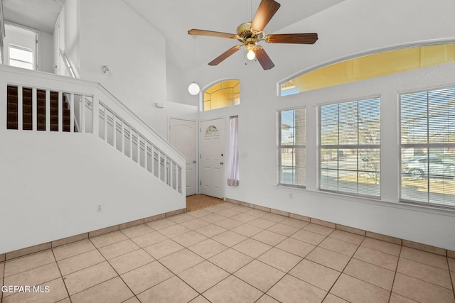 foyer entrance featuring high vaulted ceiling, ceiling fan, and light tile patterned flooring