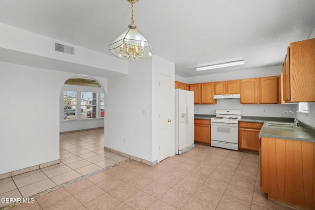 kitchen with sink, white appliances, and hanging light fixtures