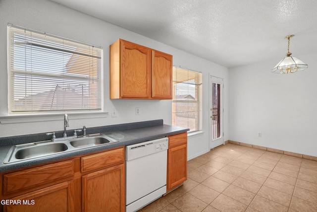 kitchen with dishwasher, sink, decorative light fixtures, light tile patterned floors, and a textured ceiling