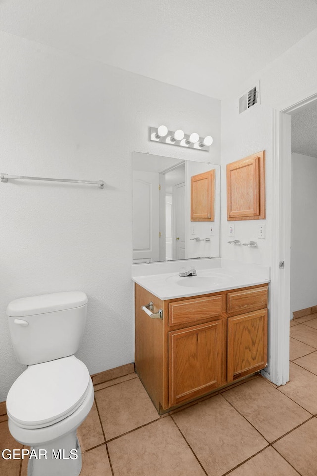 bathroom with vanity, toilet, and tile patterned flooring