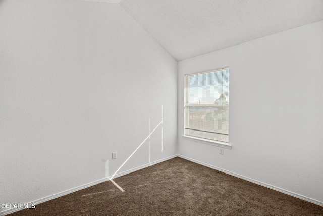 carpeted empty room with vaulted ceiling and a textured ceiling