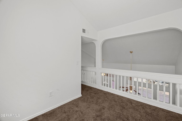 carpeted empty room featuring vaulted ceiling