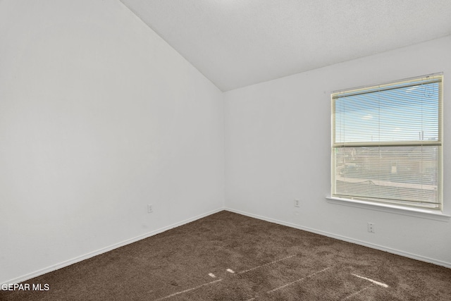 carpeted empty room featuring vaulted ceiling