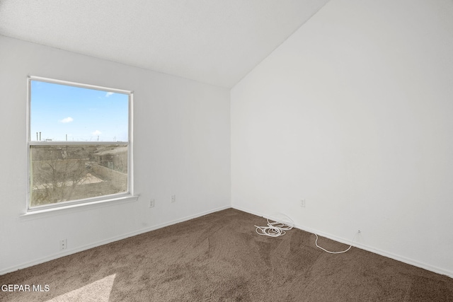 carpeted spare room with vaulted ceiling