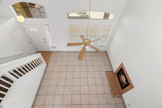 tiled entryway featuring ceiling fan and a high ceiling