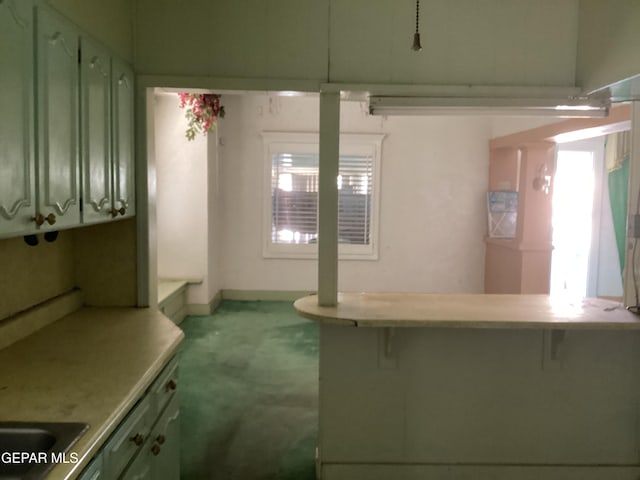 kitchen featuring light carpet and green cabinets