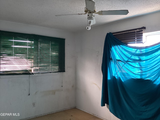 unfurnished room featuring ceiling fan and a textured ceiling