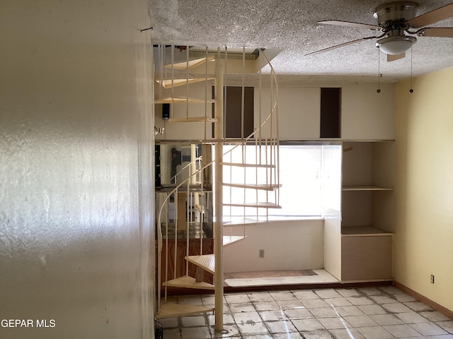 unfurnished room featuring light tile patterned flooring, a textured ceiling, and ceiling fan