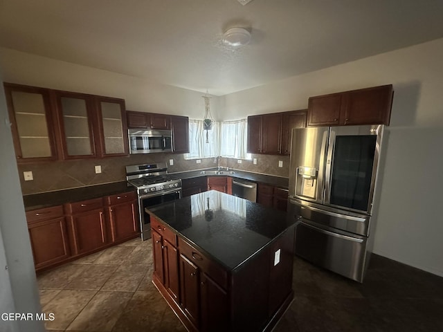 kitchen featuring a kitchen island, tasteful backsplash, appliances with stainless steel finishes, and sink