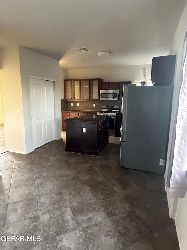 kitchen featuring appliances with stainless steel finishes, a center island, and decorative backsplash