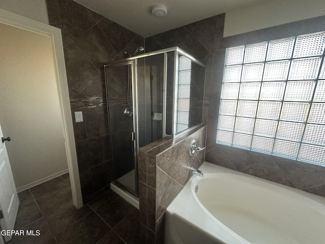 bathroom with tile patterned floors and shower with separate bathtub