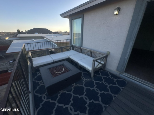 balcony at dusk featuring an outdoor fire pit