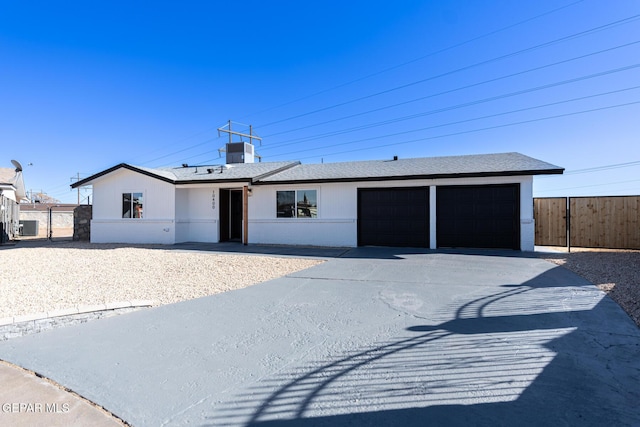 ranch-style house featuring a garage and central AC unit