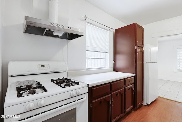 kitchen with white appliances, light hardwood / wood-style floors, and extractor fan