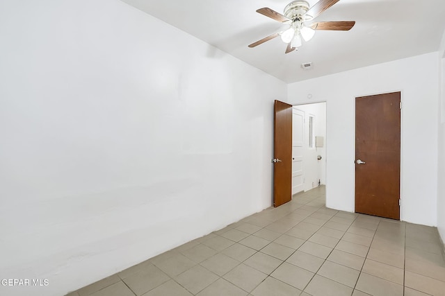 tiled spare room featuring ceiling fan