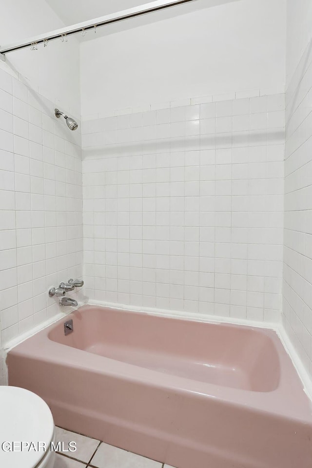 bathroom featuring bathtub / shower combination, toilet, and tile patterned flooring