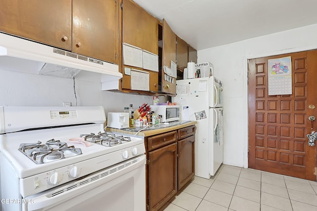 kitchen with light tile patterned floors and white appliances