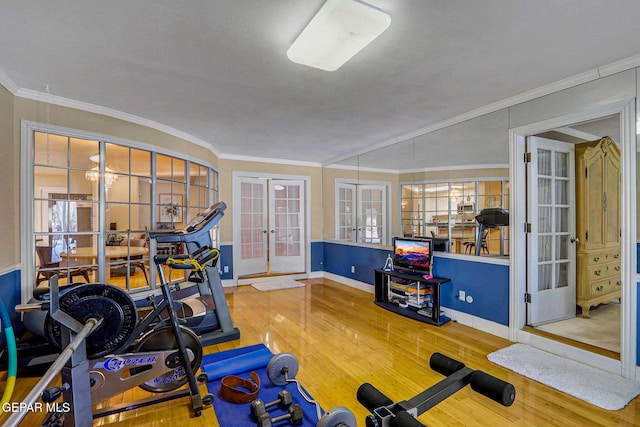 exercise area featuring french doors, ornamental molding, and hardwood / wood-style flooring