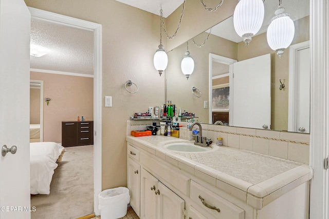 bathroom featuring ornamental molding, a textured ceiling, decorative backsplash, and vanity