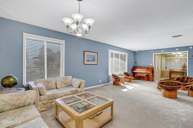 living room featuring an inviting chandelier, light carpet, and a textured ceiling