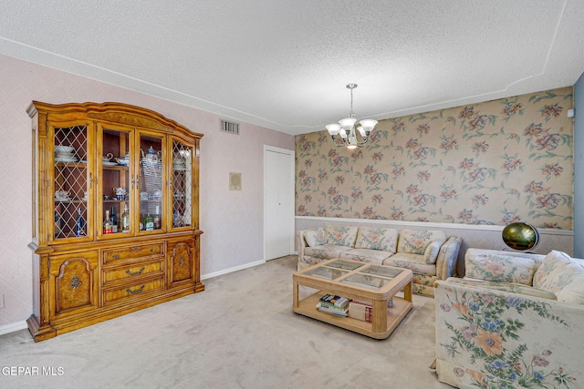 carpeted living room with a textured ceiling and an inviting chandelier