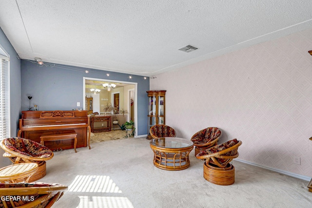 living area with a chandelier, carpet floors, and a textured ceiling