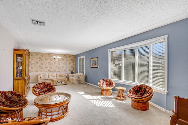 interior space with an inviting chandelier, a textured ceiling, and carpet flooring