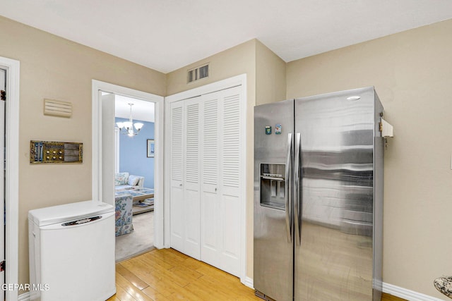 kitchen with an inviting chandelier, refrigerator, stainless steel fridge with ice dispenser, and light hardwood / wood-style flooring