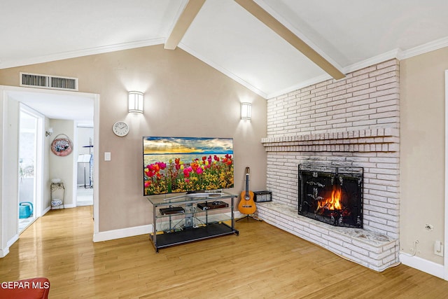 living room with crown molding, a fireplace, lofted ceiling with beams, and hardwood / wood-style floors