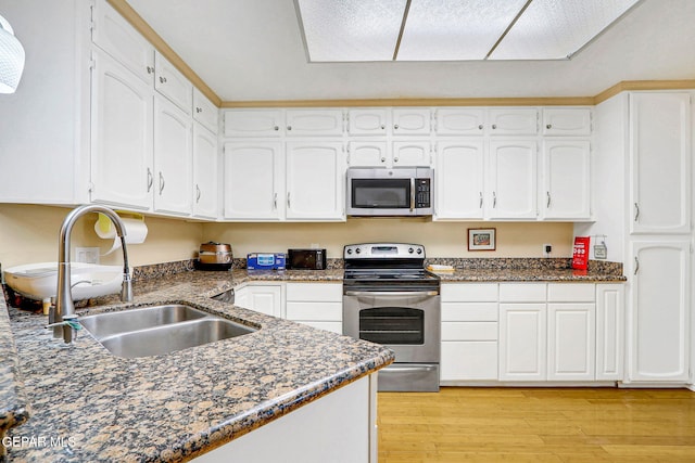 kitchen featuring white cabinetry, appliances with stainless steel finishes, sink, and light hardwood / wood-style flooring