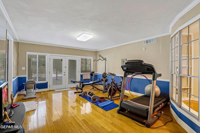 workout room featuring hardwood / wood-style flooring, ornamental molding, a textured ceiling, and french doors