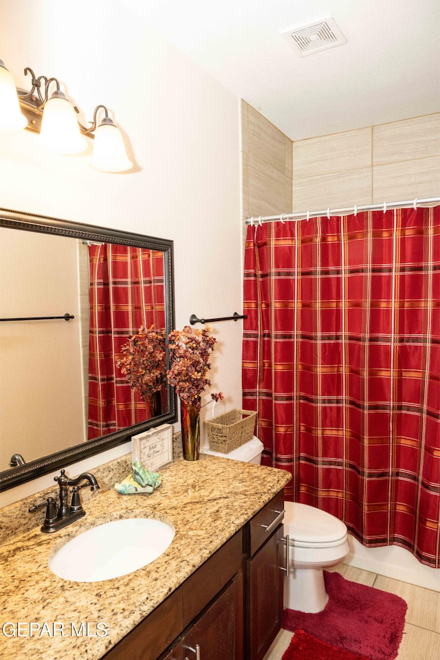 bathroom featuring vanity, tile patterned floors, and toilet