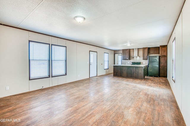 unfurnished living room featuring hardwood / wood-style floors and a textured ceiling