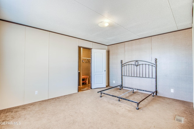 unfurnished bedroom with crown molding, a closet, and carpet