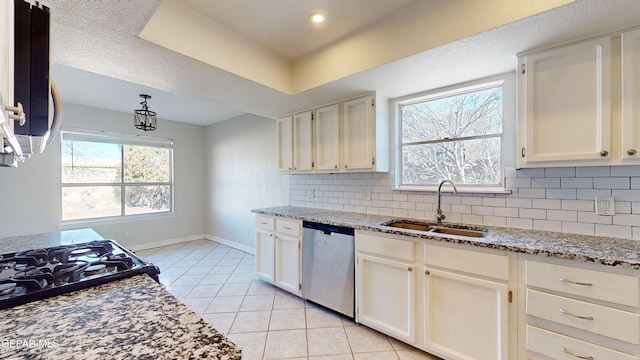 kitchen with sink, light stone counters, light tile patterned floors, stainless steel dishwasher, and backsplash