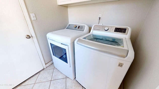 clothes washing area featuring separate washer and dryer and light tile patterned floors