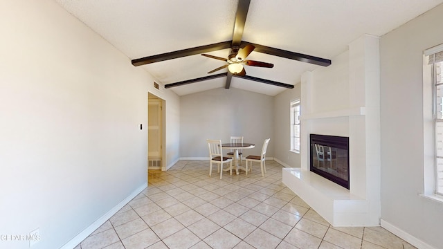 unfurnished dining area featuring vaulted ceiling with beams, ceiling fan, and light tile patterned flooring