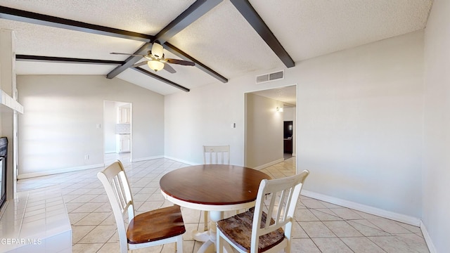 dining space featuring light tile patterned floors, lofted ceiling with beams, a textured ceiling, and ceiling fan