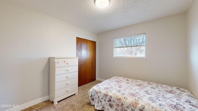 bedroom with carpet floors, a closet, and a textured ceiling