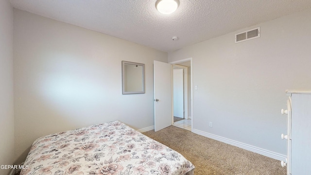 carpeted bedroom featuring a textured ceiling