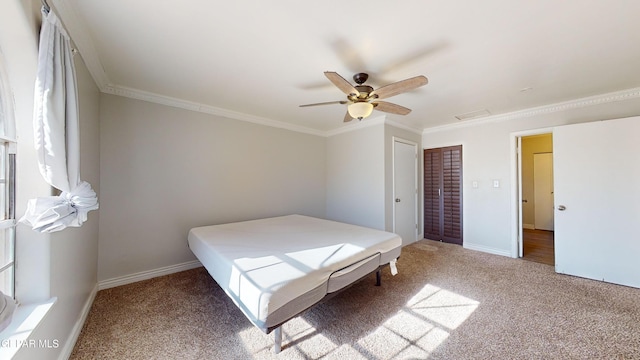 unfurnished bedroom with crown molding, a closet, ceiling fan, and carpet