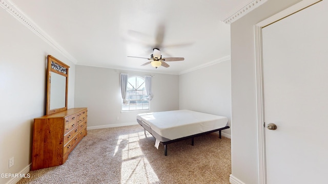 carpeted bedroom featuring crown molding and ceiling fan