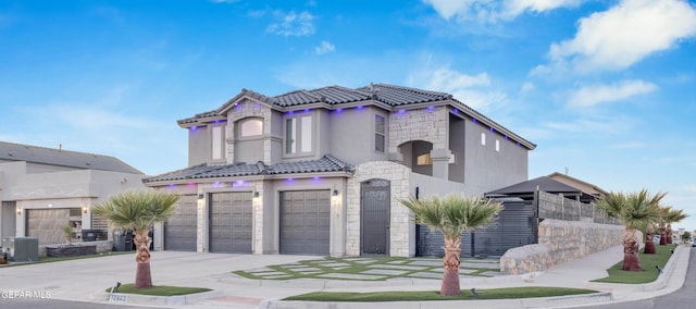 mediterranean / spanish-style home featuring a garage and central air condition unit