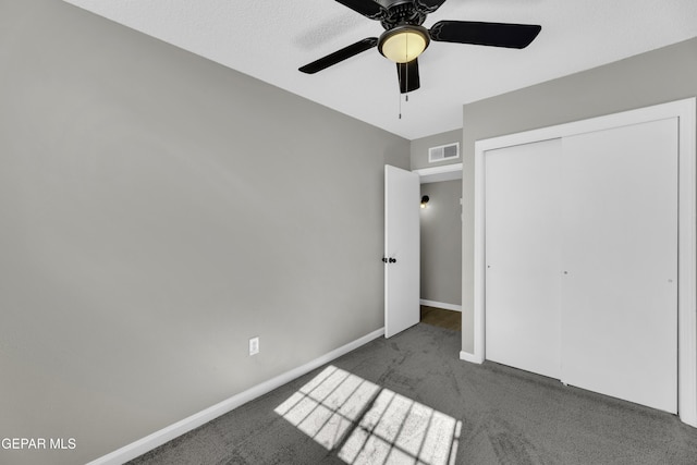 unfurnished bedroom featuring a closet, ceiling fan, and dark colored carpet