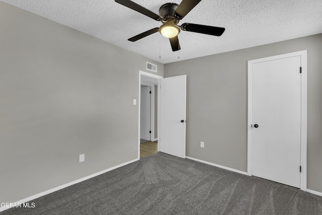 interior space with ceiling fan, a textured ceiling, and dark colored carpet