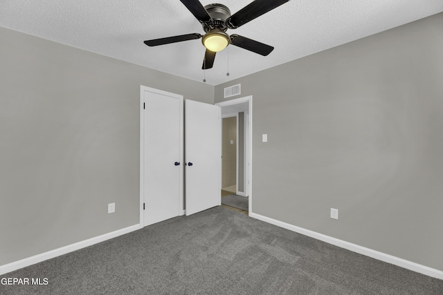 unfurnished bedroom featuring a closet, ceiling fan, carpet floors, and a textured ceiling