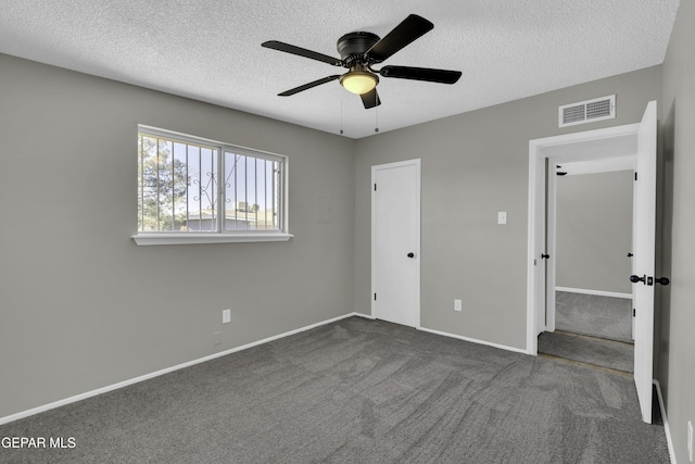 unfurnished bedroom with dark carpet, a textured ceiling, and ceiling fan