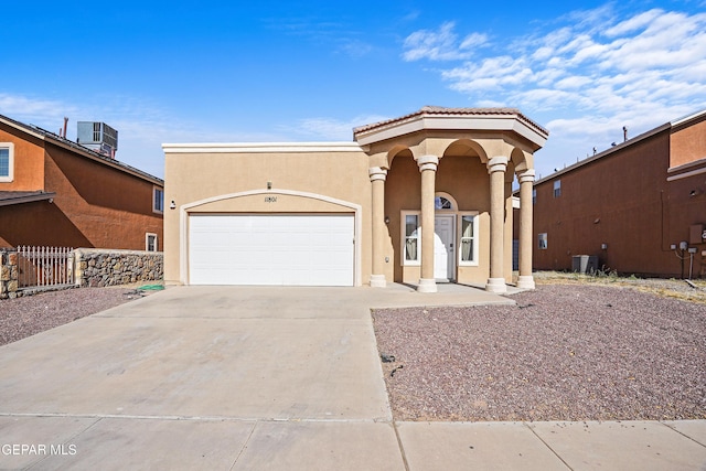 view of front of property featuring a garage and central air condition unit