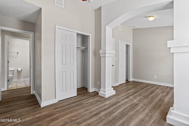 unfurnished bedroom featuring dark wood-type flooring and a textured ceiling